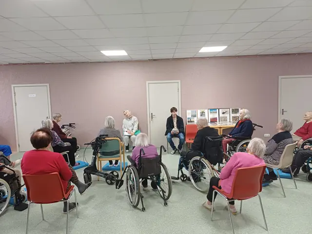 Brīvprātīgais un senioru mājas iemītnieks spēlē dambreti saulainā dārzā